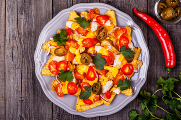 Nachos with melted cheese sauce, jalapeno, chicken and vegetable