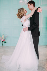 Fototapeta na wymiar Happy couple. Wedding photo shoot in the white studio with wedding decor kisses, hugs