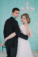 Happy couple. Wedding photo shoot in the white studio with wedding decor kisses, hugs