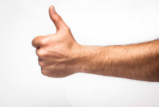 male hand showing thumbs up sign against