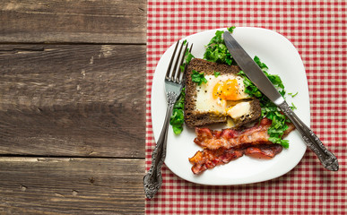 Fried egg in rye bread with bacon and parsley