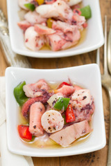 salad with octopus in bowl on brown background