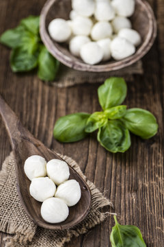 Small Mozzarella balls (on wooden background)