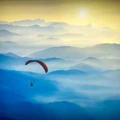 Rolgordijnen Paraglide silhouette in a light of sunrise © Bashkatov