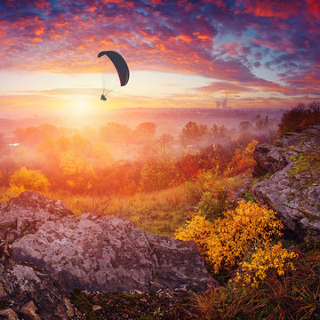Paraglide in a sky above the misty valley