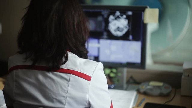 Experienced doctor looking at MRI scan of lumbar region on Monitor