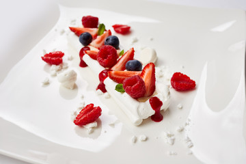 meringue cake decorated with fruit, strawberries, raspberries, b