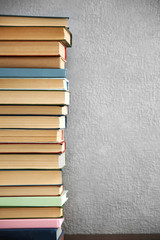Stack of books on grey wall background