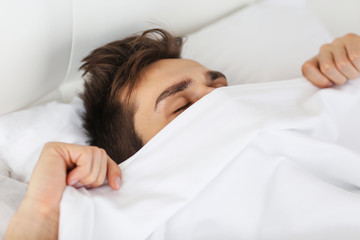 Fototapeta na wymiar Morning concept. Man under covering in bed.