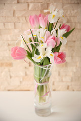 Beautiful bouquet of fresh flowers against brick wall background