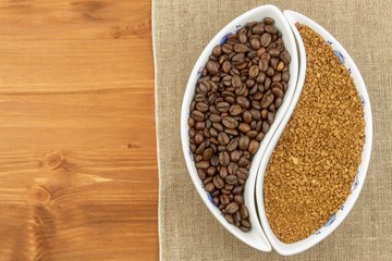 Natural coffee beans versus instant. Soluble and coffee beans on wooden background. Preparing fresh coffee. Sales of roasted coffee. Advertising for the sale of coffee.

