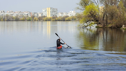 a man kayaking on a background of the city, turn to kayak