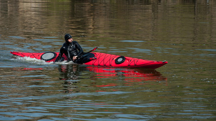 a man in a diving suit makes a coup by kayak