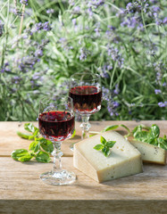 Cheese with red wine on wooden table outdoors