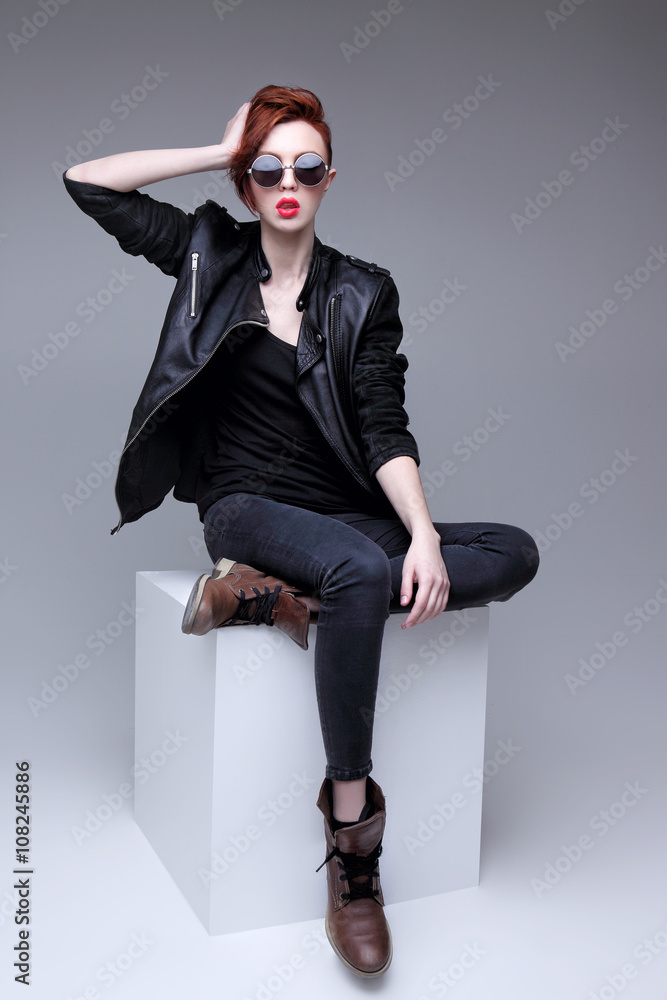 Wall mural redhead fashion model in sunglasses and black leather jacket