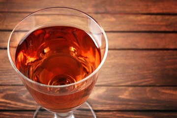 Glass of wine on wooden table. Top view