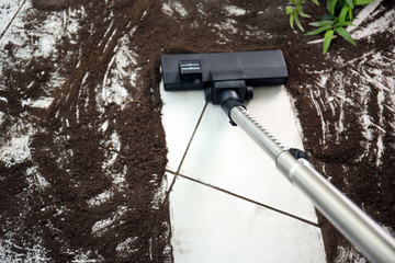 Vacuum cleaning after falling flower pot on a tiled floor