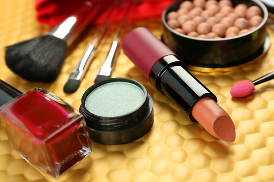 Makeup set with brushes and cosmetics on yellow background