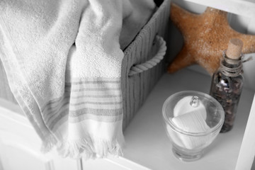 Bathroom set with towels, starfish and sponges on a light shelf