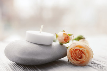 Obraz na płótnie Canvas Spa stones with beautiful flowers and candle on white wooden table