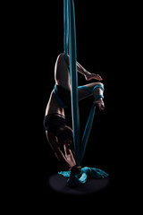 Young woman gymnast with blue gymnastic aerial silks