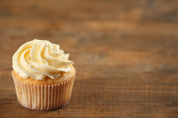 Delicious tasty cupcake on wooden table