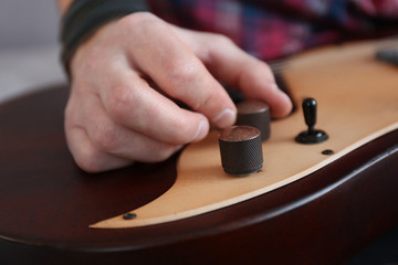 Man setting up electric guitar closeup