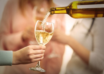 Pouring white wine into glass at hen-party, close up