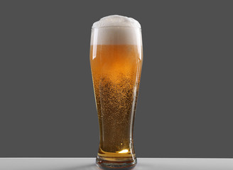 Glass of lager beer on grey background