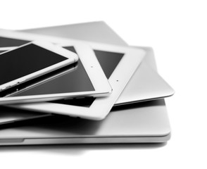 Stack of electronic devices on a white desk