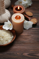 Obraz na płótnie Canvas Spa set with sea salt, exotic flowers and candles on wooden background