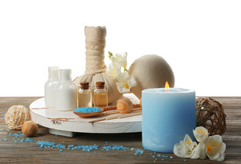 Obraz na płótnie Canvas Spa composition with sea salt in a bowl, massage balls and flowers on wooden table against white background
