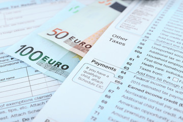 1040 Income Tax Form and euro bills, close up