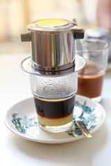 Traditional Penang kopitiam (or kopi tiam) style milk coffee in vintage mug, fractal on the cup is generic print. Close-up view with dramatic, ambient light on wooden background