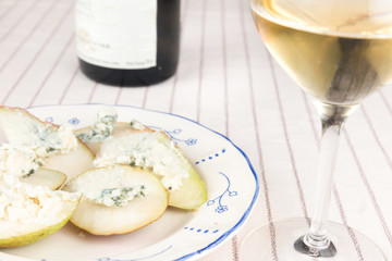 Blue cheese on pear wedges with glass of white wine