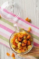 Raw pasta on wooden table, top view
