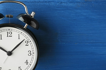 Alarm clock on old wooden table.
