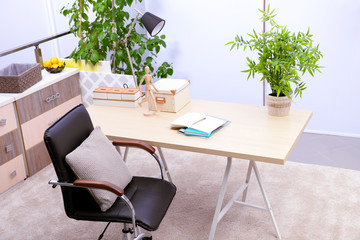 Workplace with table, office chair and lamp in living room
