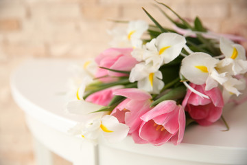 Beautiful bouquet of fresh tulips and irises on wooden table closeup