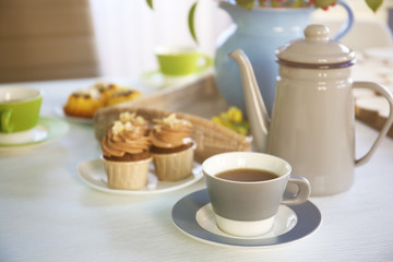 Obraz na płótnie Canvas Tea and cakes on wooden table indoors