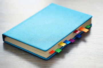 Blue dairy with multicoloured stickers on wooden background