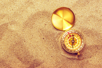 Top view of vintage compass in beach sand