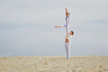  Attractive adult couple is balancing doing acro-yoga