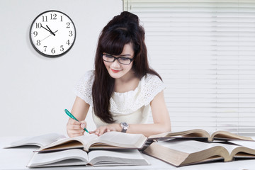 Student prepares exam while reading books