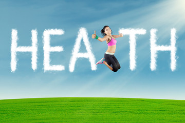 Woman jumping with health text at field