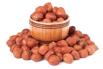 peeled hazelnuts in a wooden bowl on  white background