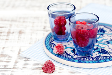 close up of a cold drink with raspberries.