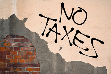 Handwritten graffiti No Taxes sprayed on the wall, anarchist aesthetics 