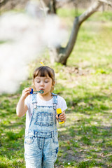 little girl inflates soap bubbles