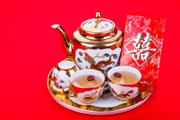 Generic traditional Chinese tea set with generic red envelope bearing the word double happiness, in white background